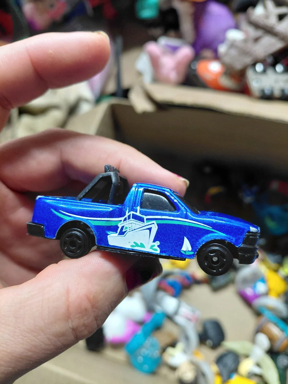 blue diecast pickup truck is a 1:64 scale model, possibly from a 